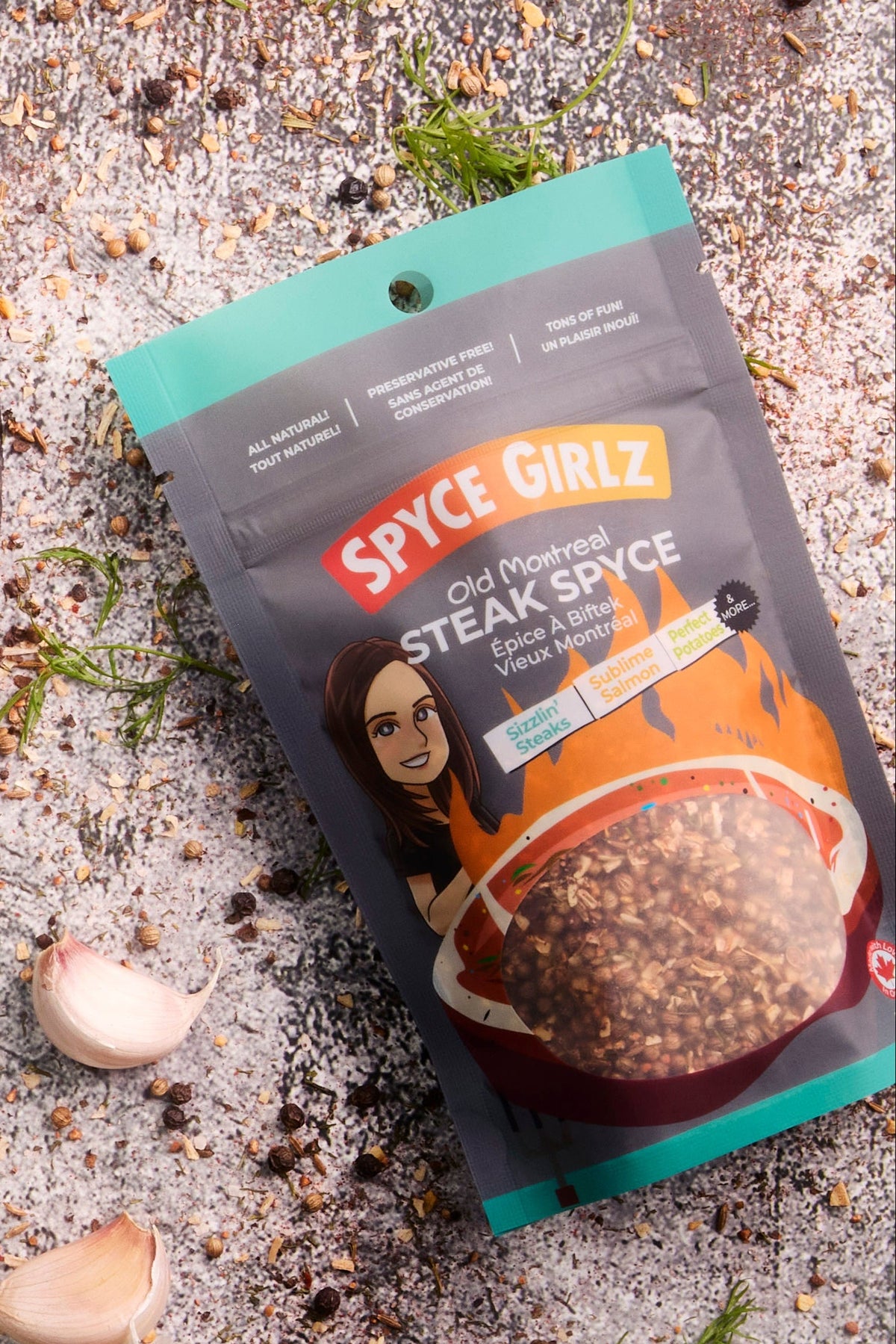 Skillet with steak, asparagus, and potatoes on a concrete surface with a Spice Islands seasoning packet.